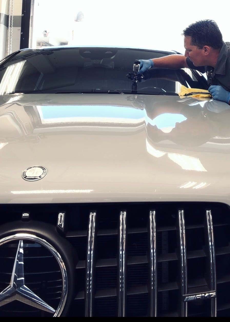 Technician performing precision rock chip repair on a windshield